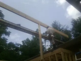 Carpenter setting a ridge beam over a new addition frame — Ice Dam Removal by Roofing Brothers in Owatonna