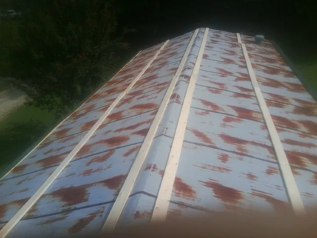 Rusted metal roof panels with new wood purlins before replacement — Storm Damage Roof Repair in Owatonna by Roofing Brothers