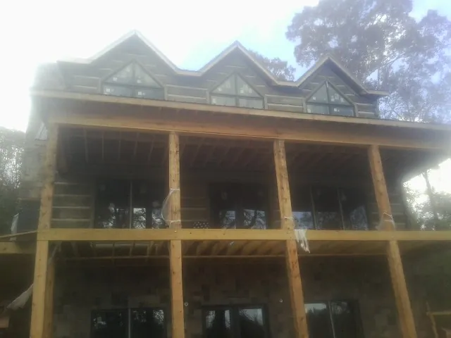 Dormers and porch framing on a large log home under construction — Roof Coating work by our crew in Owatonna