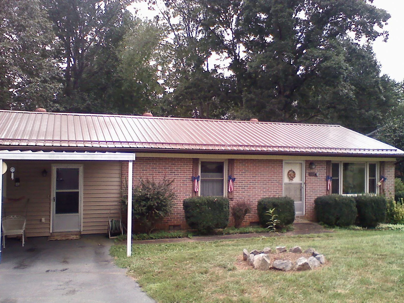 Bronze metal roof and carport on a brick ranch home — Roof Repair work by our crew in Owatonna